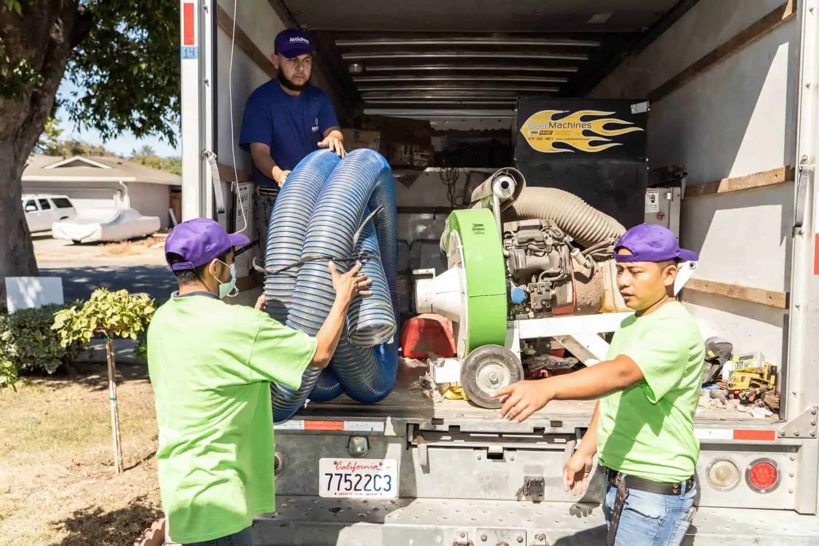 Attic Pros professionals putting tubing on work truck