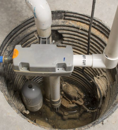 A sump pump installed in a basement of a home with a water powered backup system.